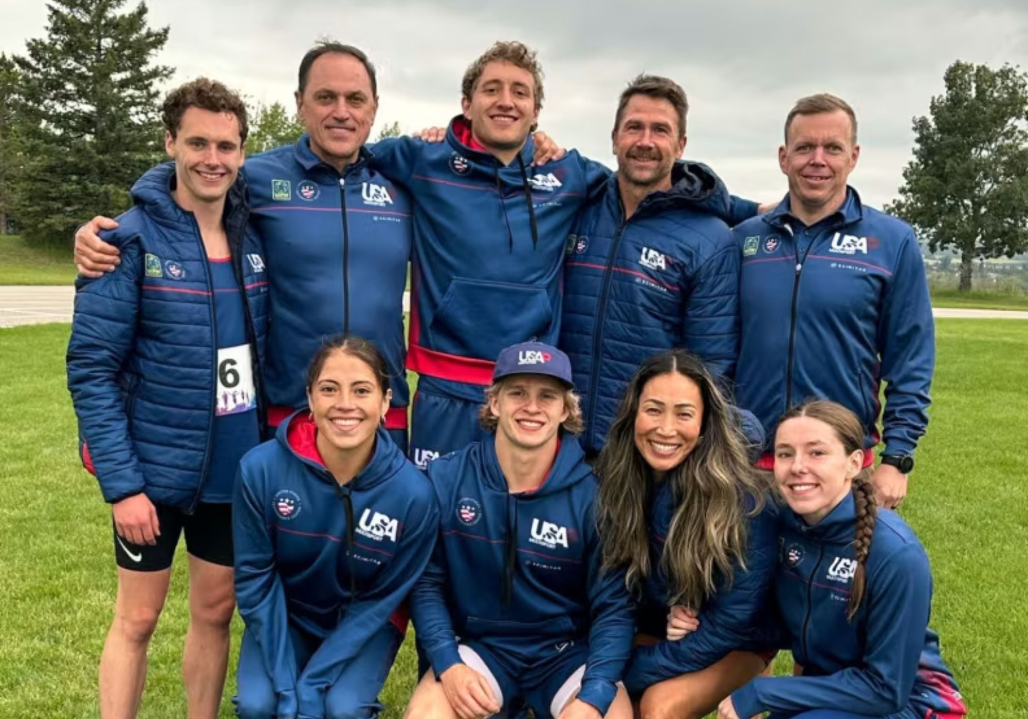 Group of USA Pentathlon Multisport athletes and coaches smiling in USAPM uniforms